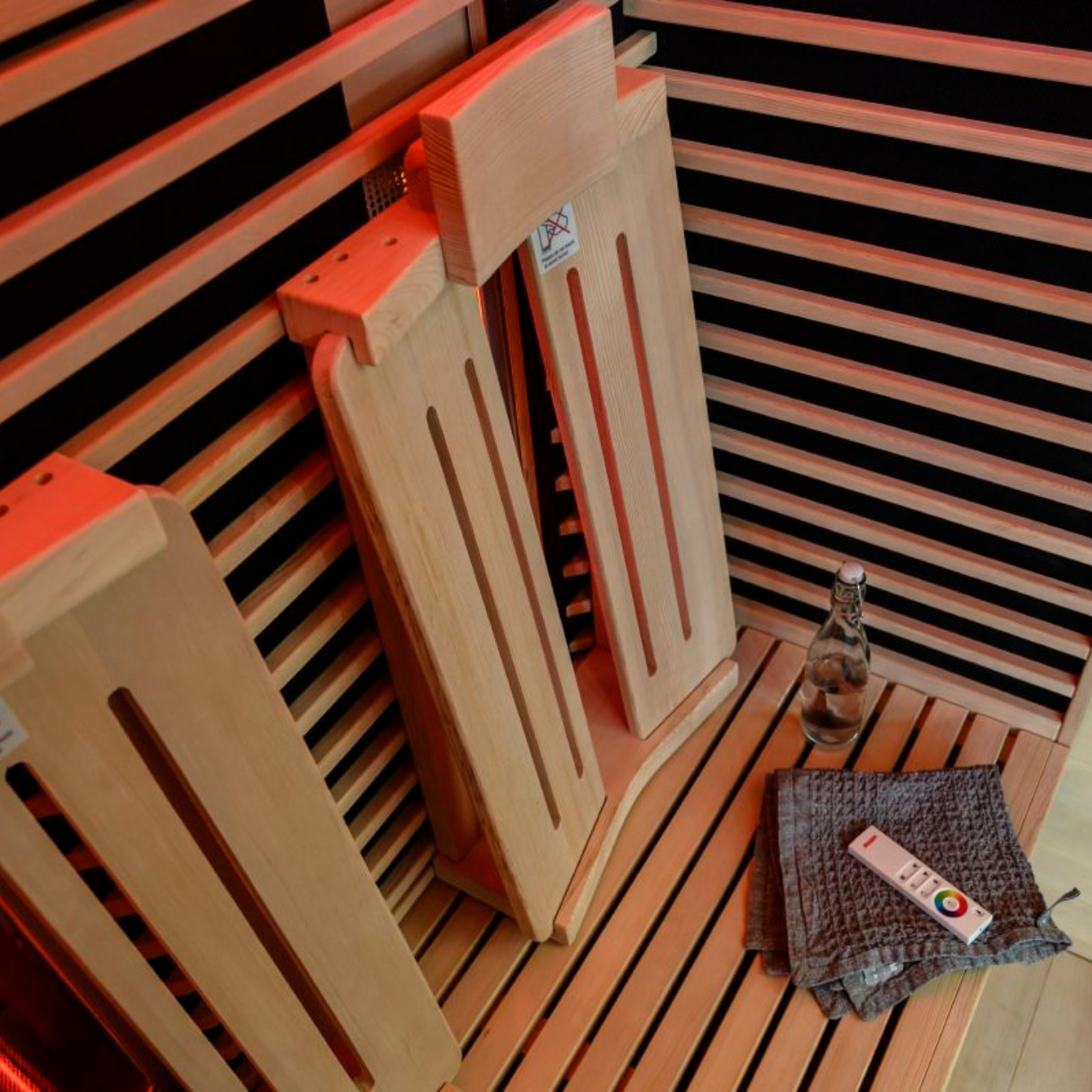 Close-up of an infrared sauna cabin corner with wood slats and remote control